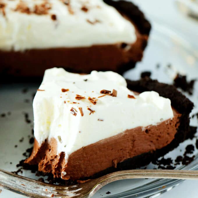 A slice of no bake chocolate pie with a bite taken out of it and a fork off to the side.