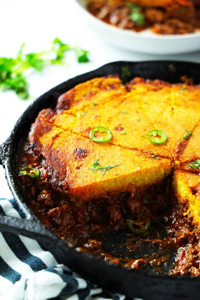Tamale Pie in a skillet with a slice cut out of it.
