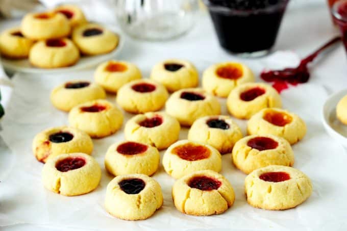 Thumbprint cookies on a sheet of parchment papper.