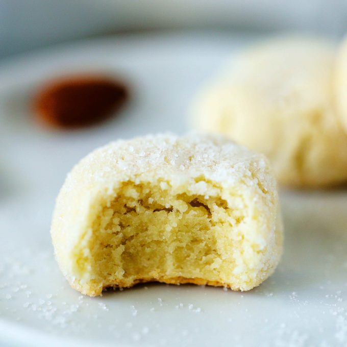 An amaretti cookie on a plate with sugar around it.