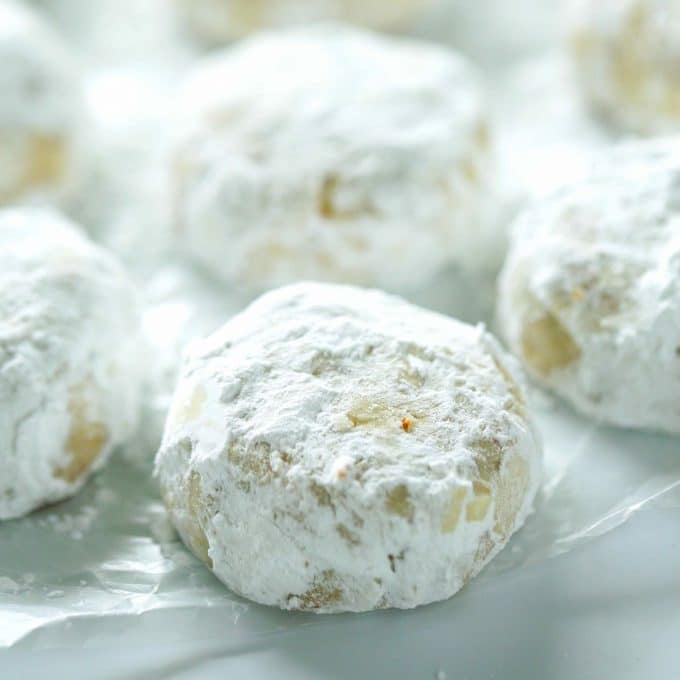 Italian Wedding Cookies rolled in powdered sugar and place on crinkled paper.