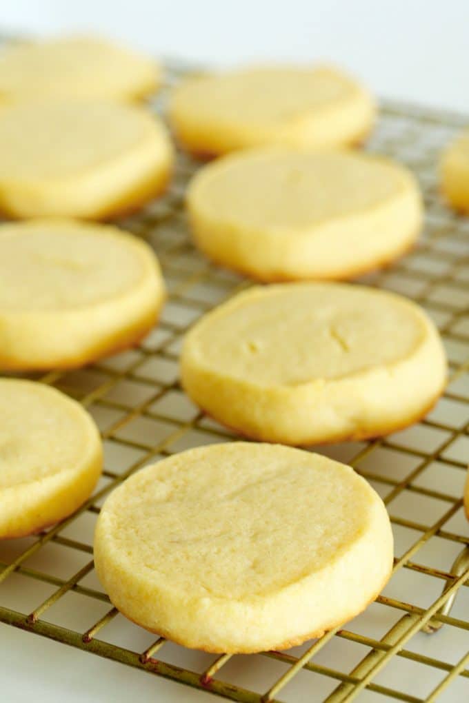 Soft sugar cookies spread out on a cooling rack.