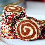 Christmas colored pinwheel cookies clustered together on a white plate.