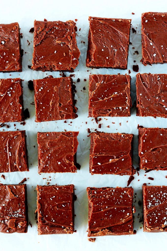 An overhead shot of marshmallow fudge cut into small squares on a white surface.