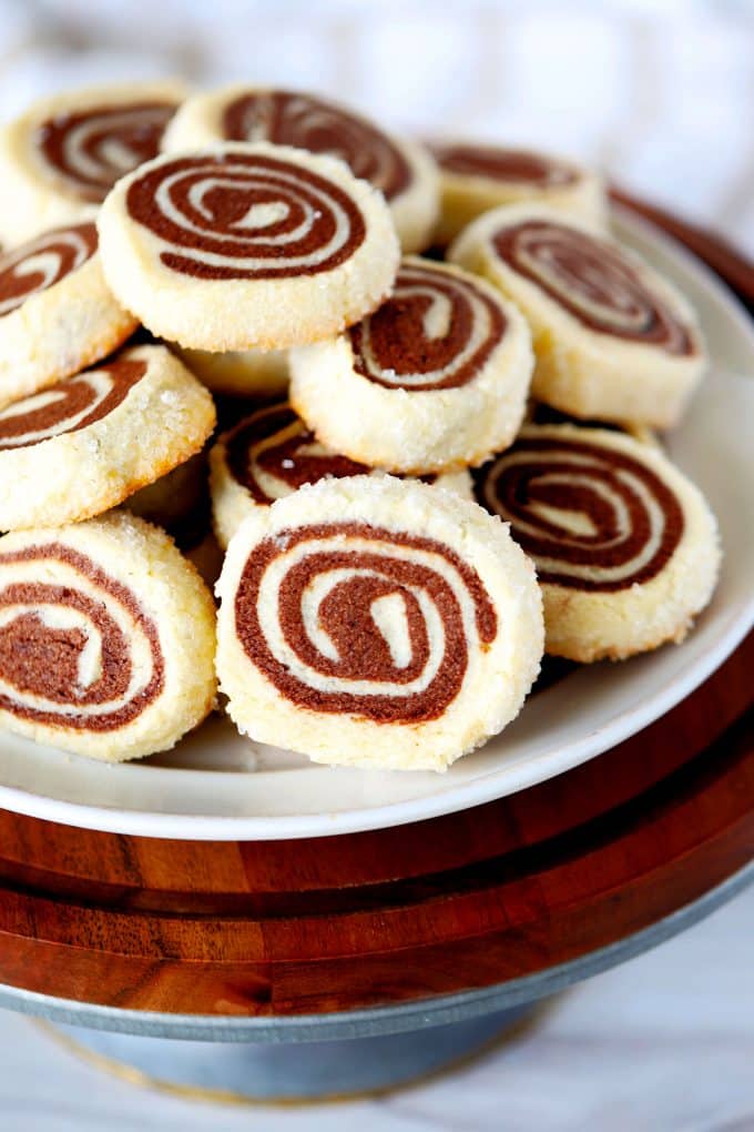 Chocolate Pinwheel Cookies on a wooden cake stand.