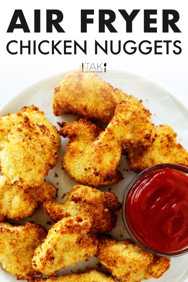 Image For Pinterest. Air fryer chicken nuggets on a white plate. There is a bowl of ketchup off to the side.