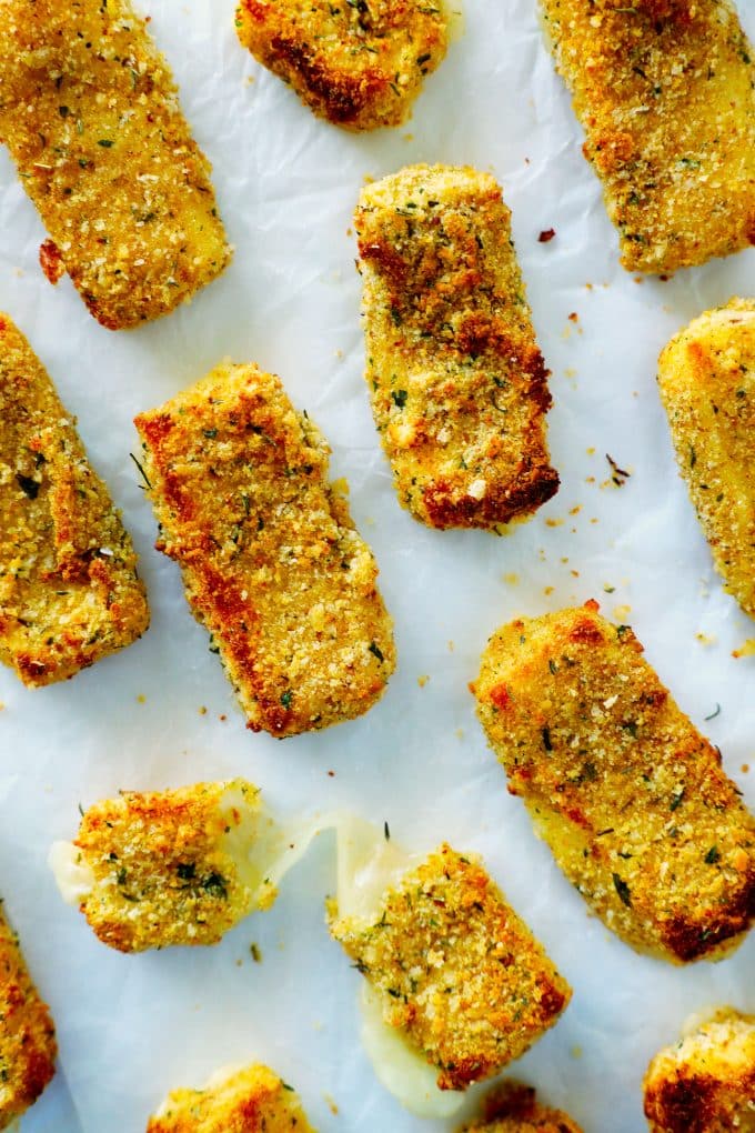 Air fryer cheese sticks on a baking sheet lined with parchment paper.