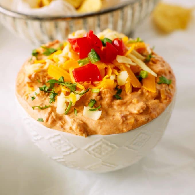 Cream cheese salsa dip with tomatoes and cheese and cilantro on top.