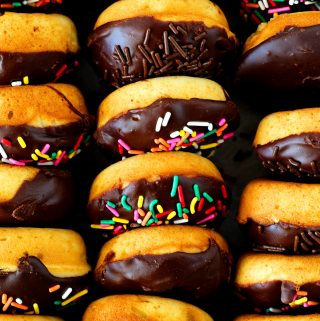 An overhead shot of baked donuts with a chocolate glaze in a box.