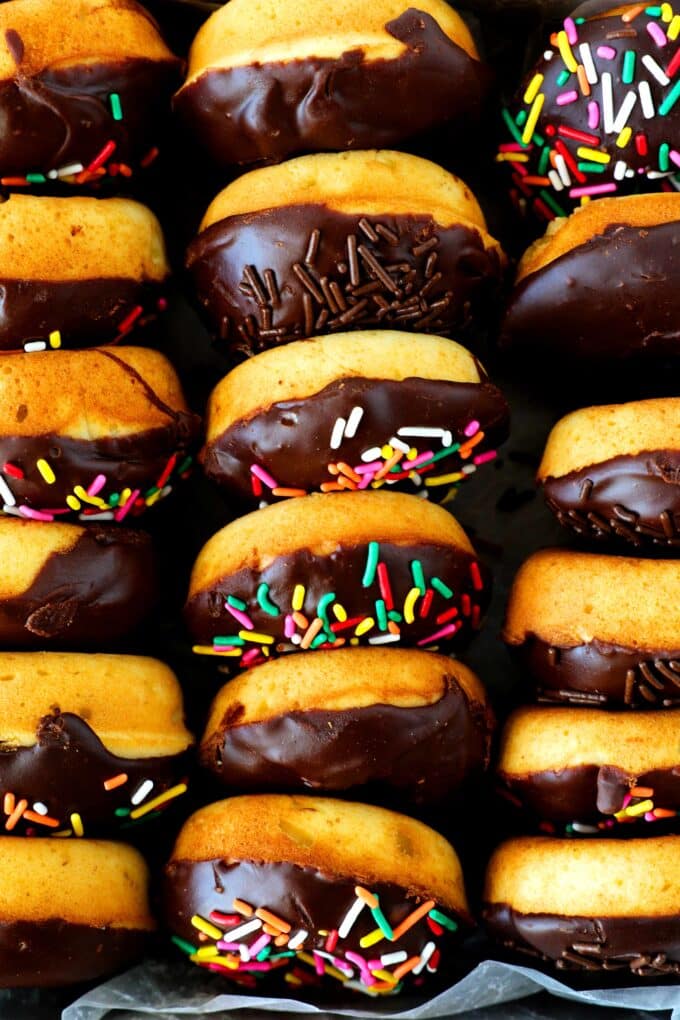 An overhead shot of baked donuts with a chocolate glaze in a box.