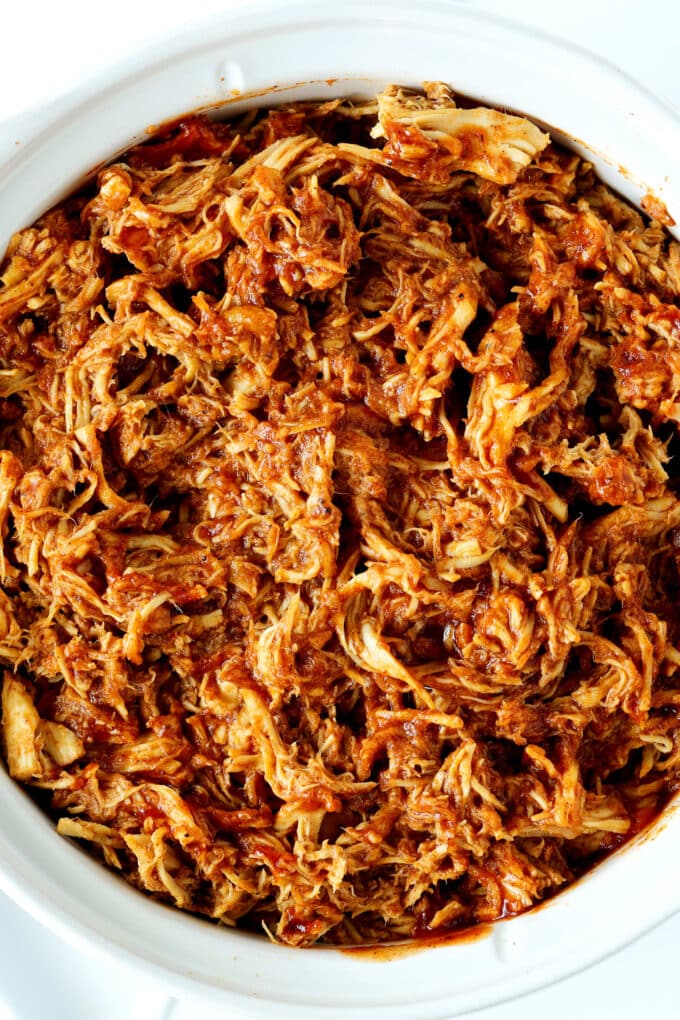 An overhead, close-up shot of slow cooker pulled chicken.
