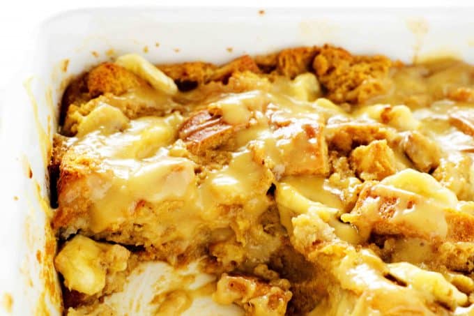 Banana bread pudding in a casserole dish with slices cut out of it.