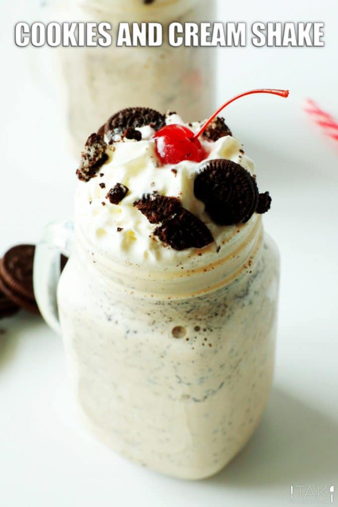 Image for Pinterest. Cookies and cream milkshake in a class cup. Topped with a swirl of whipped cream, mini oreos, and a maraschino cherry.