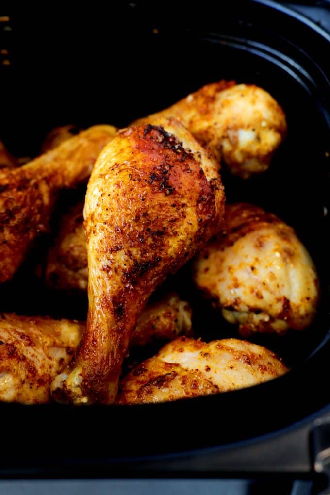 A close up shot of a chicken leg in the air fryer basket. 