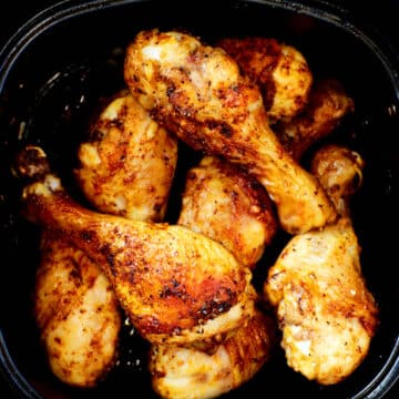 An overhead shot of cooked air fryer chicken legs in the air fryer basket.