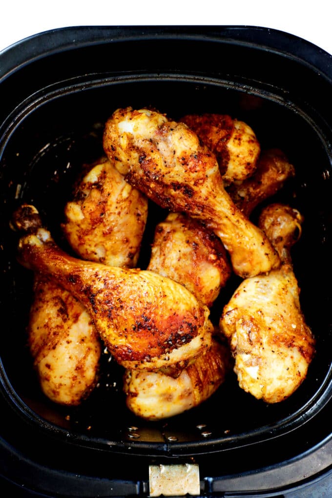 An overhead shot of cooked air fryer chicken legs in the air fryer basket.