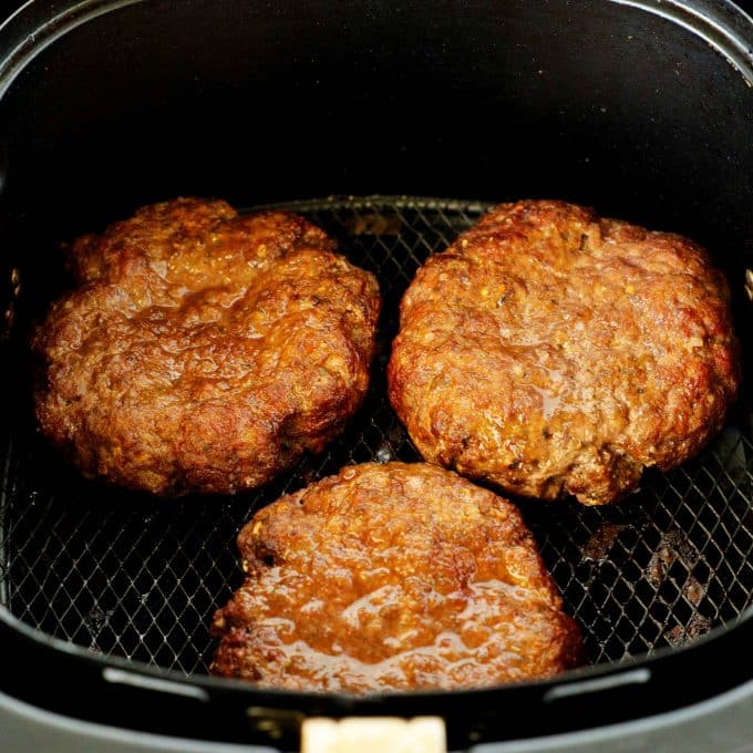 Burgers in the air fryer basket fully cooked.
