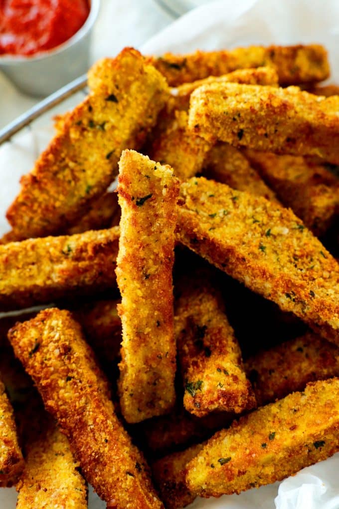 An overhead shot of crispy breaded air fryer eggplant fries with a marinara sauce off to the side.