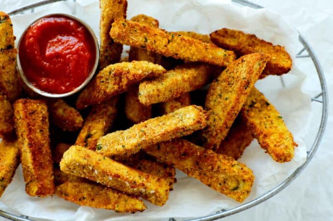 An overhead shot of a basket of crispy, breaded air fryer eggplant fries.