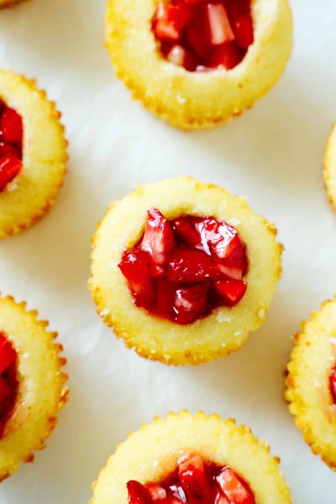 An overhead shot of vanilla cupcakes with chopped strawberries inside.