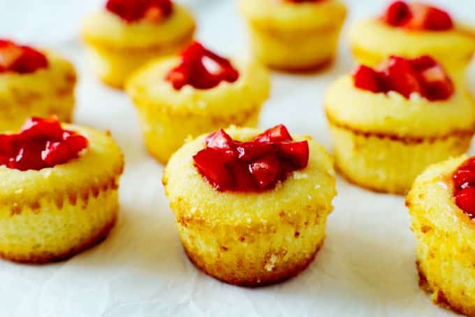 Vanilla cupcakes with chopped strawberries inside.