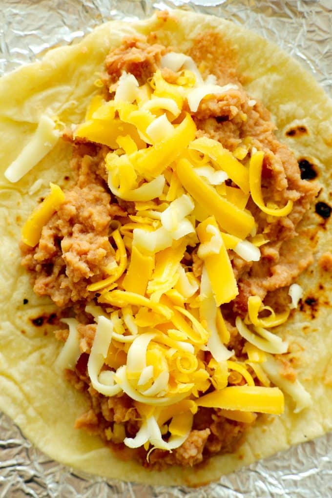 A tortilla with refried beans and cheese inside.
