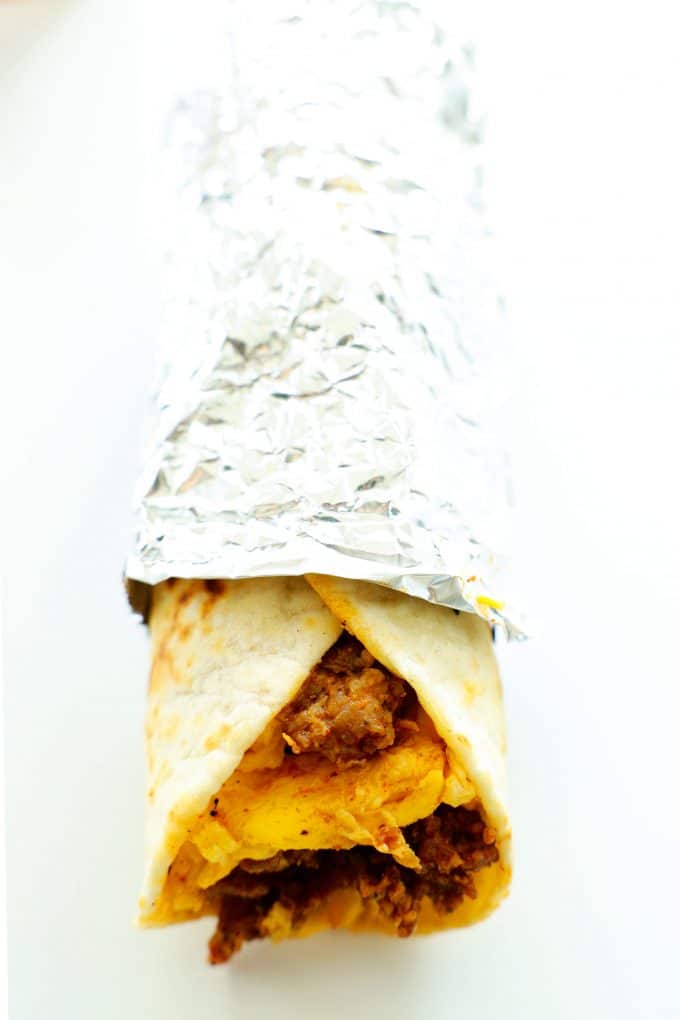 A chorizo and egg breakfast taco rolled in aluminum foil.