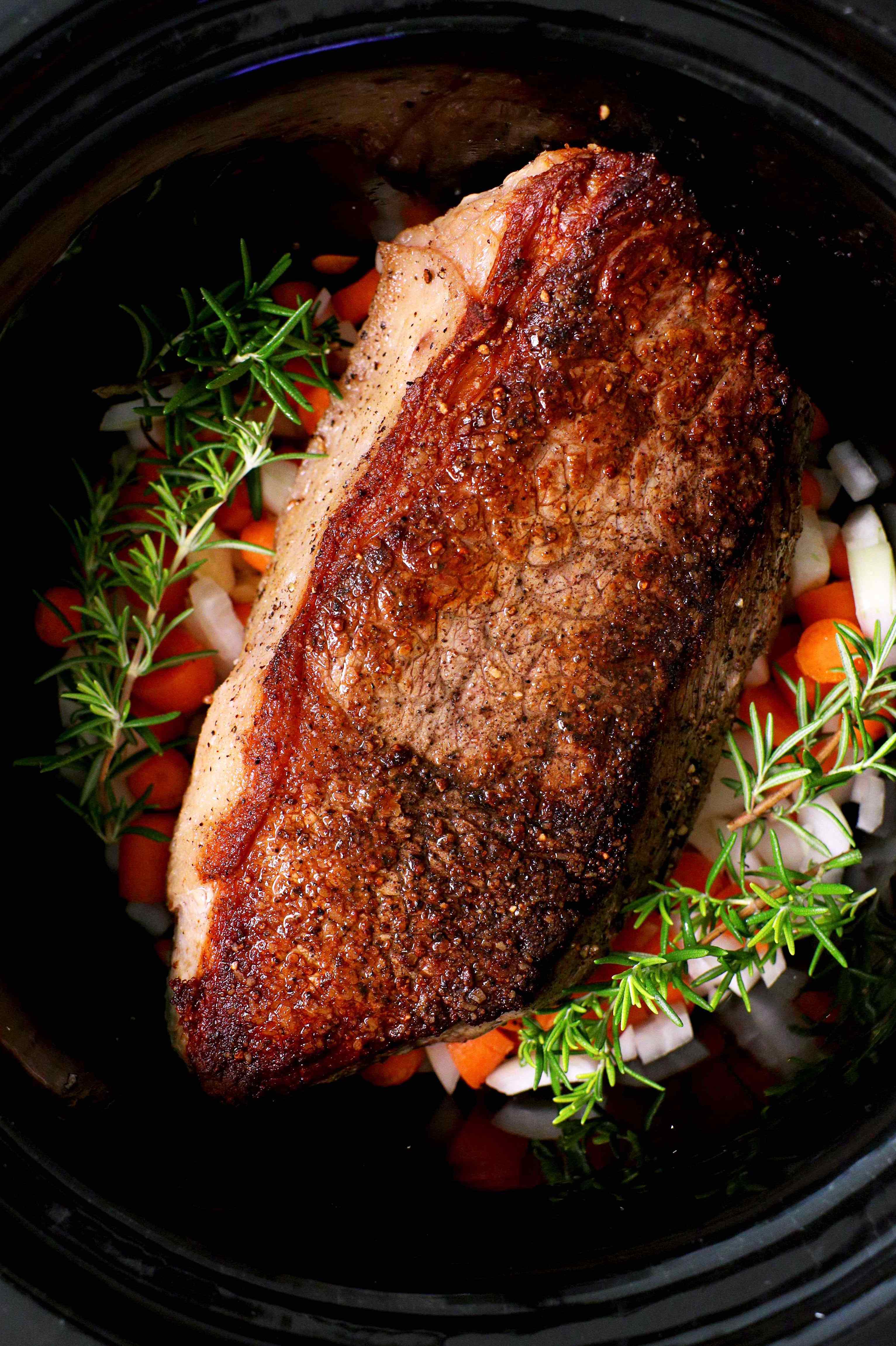 A close up shot of slow cooker rump roast on a white platter.