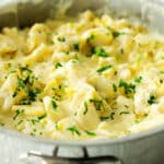 Tortellini Alfredo in a sauce pan sprinkled with parsley.