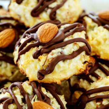 A close-up image of and almond joy cookie with a drizzle of chocolate and an Allmond on top.