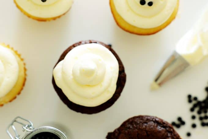 A swirl of vanilla frosting on top of a chocolate cupcake.