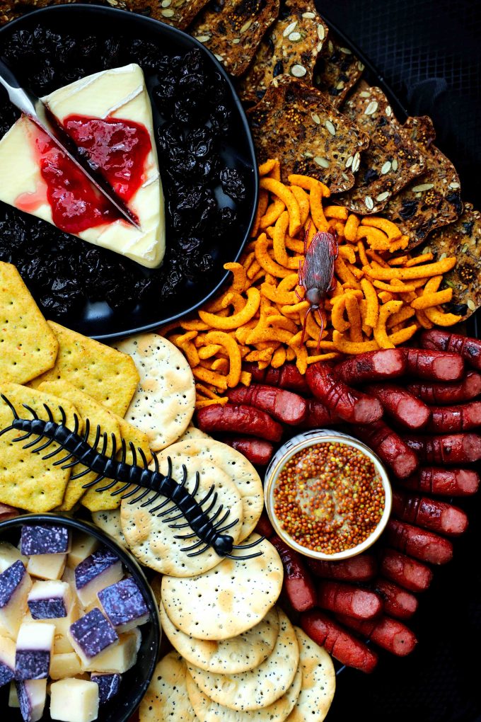 A Halloween charcuterie board with fake bugs on top of it.