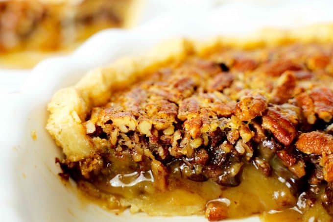 Kentucky derby chocolate bourbon pecan pie in a pie dish with a slice cut out of it so you can see the filling.
