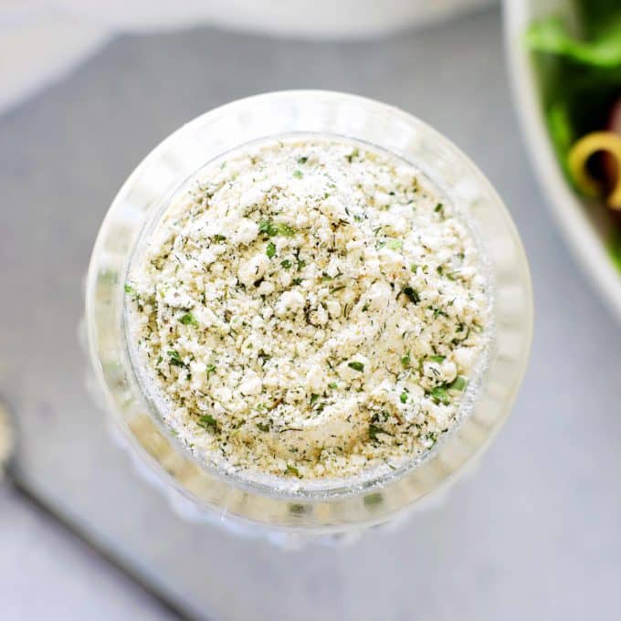 A close-up shot of ranch dressing mix in a clear bottle.