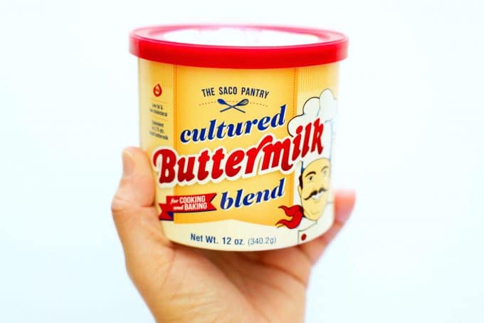 A hand holding up cultured buttermilk powder.