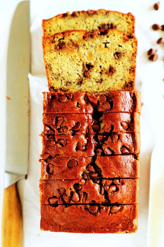 An overhead shot of chocolate chip banana bread sliced into with a knife beside it.