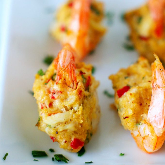 A close up of crab stuffing on top of stuffed shrimp.