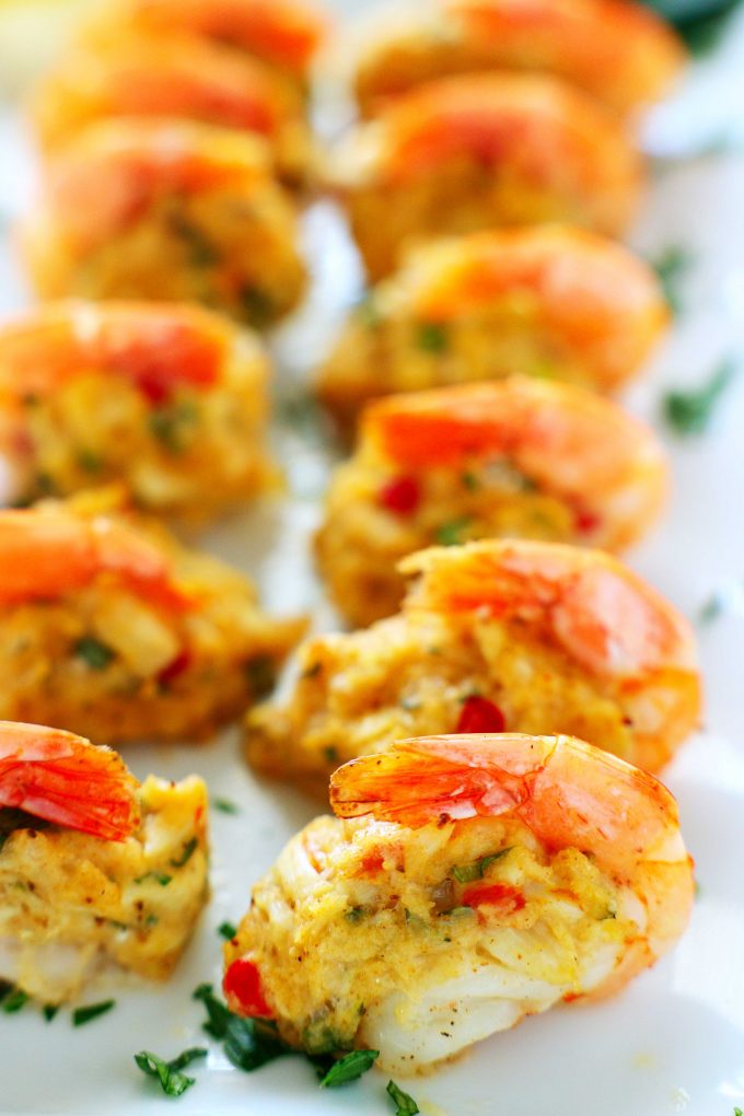 Stuffed shrimp in two rows on a white platter.