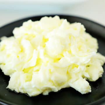 Scrambled egg whites on a black plate.