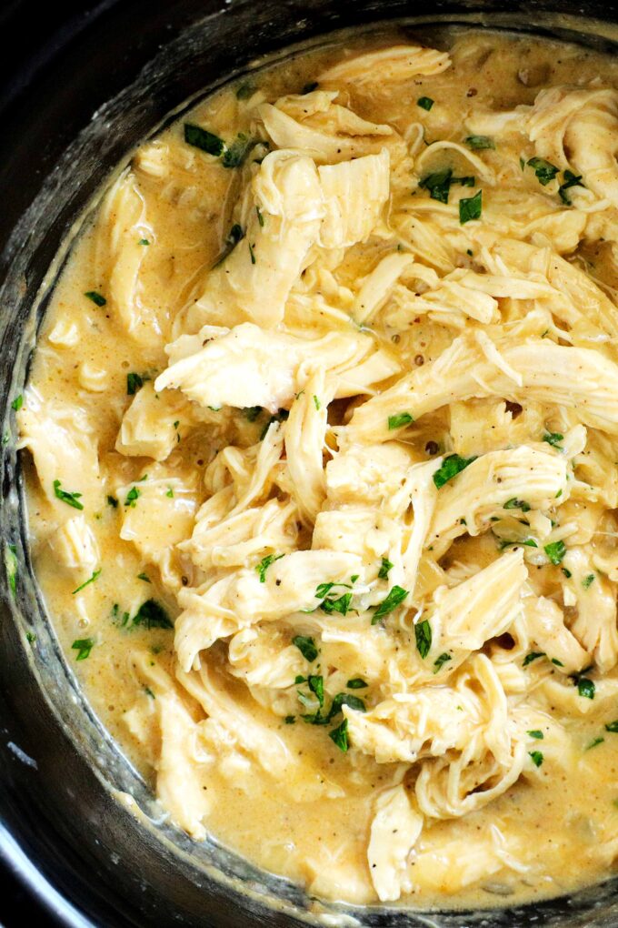 An overhead close-up shot of chicken and gravy in a crockpot.