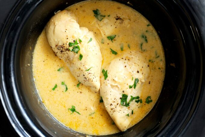Two chicken breasts in a crockpot of gravy
