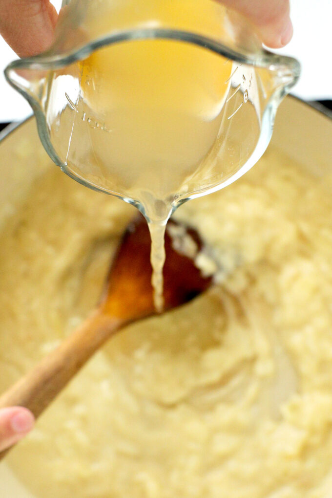 broth being poured into skillet of gravy