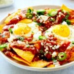 Chilaquiles Rojo with fried eggs and jalapeños