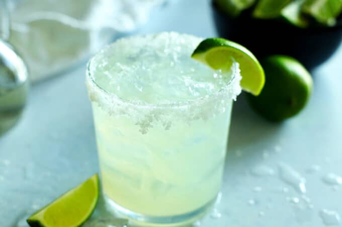 A margarita with salted rim and lime wedge on the side