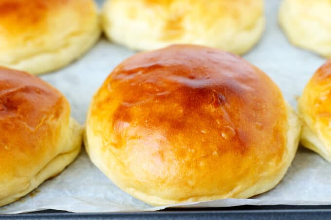 A close-up shot of potato buns on a baking sheet.