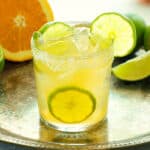 A skinny margarita with sliced citrus in the background