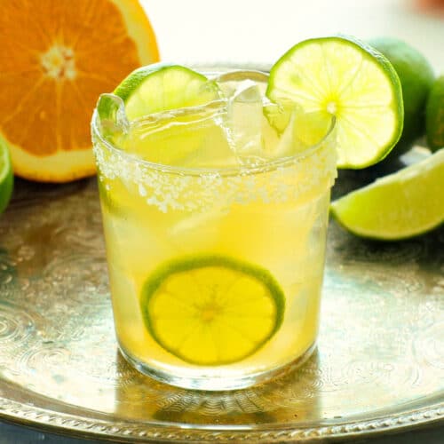 A skinny margarita with sliced citrus in the background
