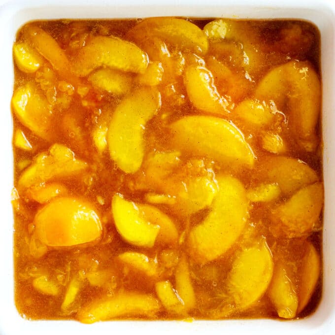 An overhead view of peach mixture in a baking dish before the topping is added
