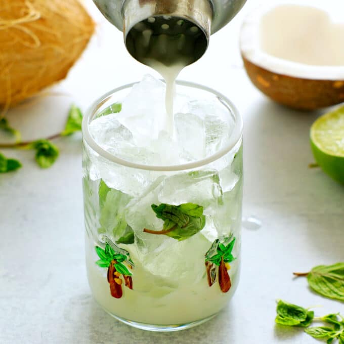 coconut Mojito being poured from a shaker into a tumbler