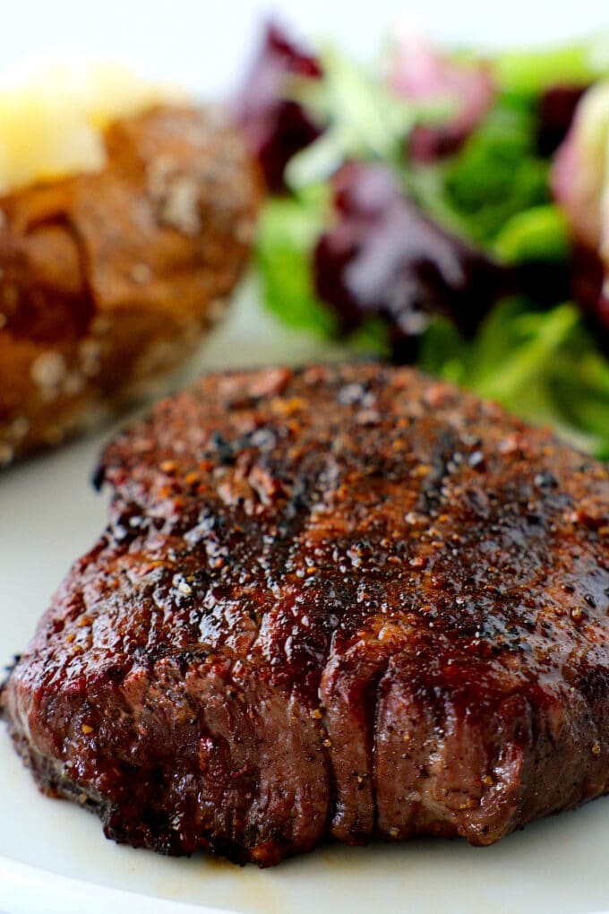 Top sirloin steak with a baked potato and side salad
